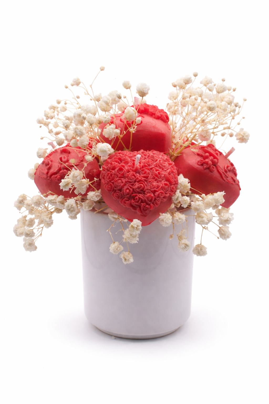 Floral arrangement in white pot with red candles